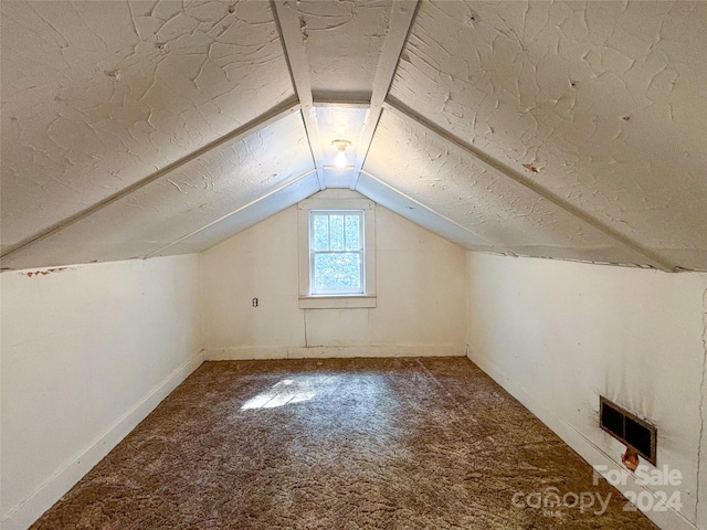 bonus room with carpet, lofted ceiling, and a textured ceiling