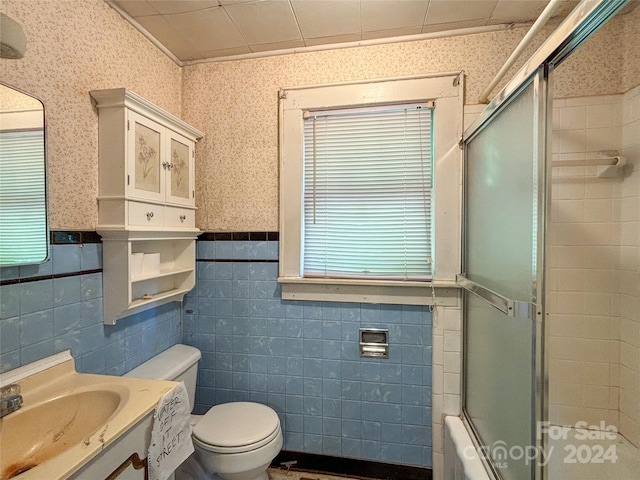 full bathroom featuring toilet, shower / bath combination with glass door, and vanity