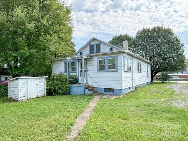 bungalow-style house featuring a storage shed and a front lawn