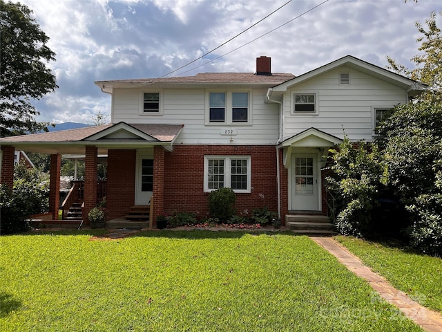 view of front of property with entry steps, brick siding, and a front lawn