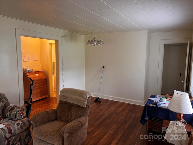 sitting room featuring baseboards, wood finished floors, and a notable chandelier