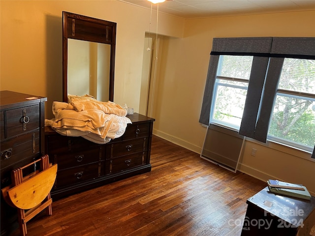 bedroom with dark wood-type flooring and baseboards