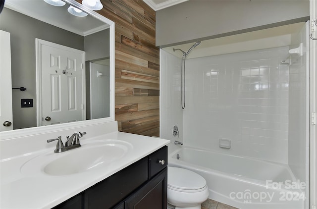 full bathroom featuring toilet, tiled shower / bath, vanity, ornamental molding, and wood walls