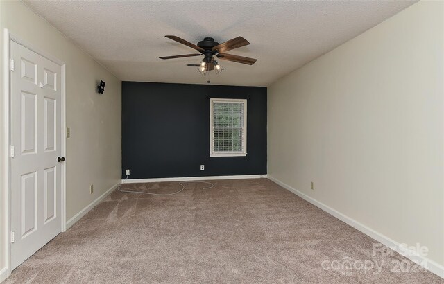 empty room with a textured ceiling, ceiling fan, and light carpet