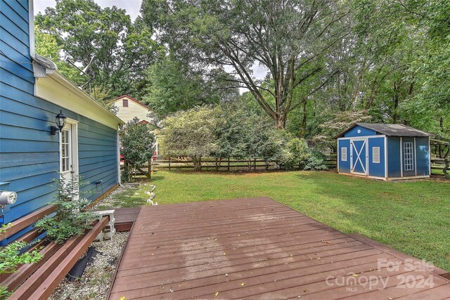 wooden deck featuring a storage shed and a lawn