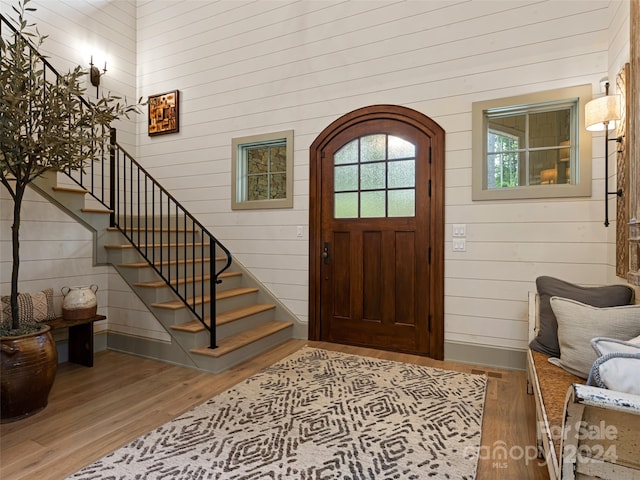 foyer featuring wooden walls and hardwood / wood-style floors