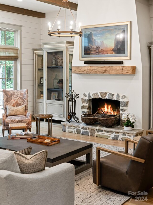 living room featuring a fireplace, a notable chandelier, and hardwood / wood-style floors