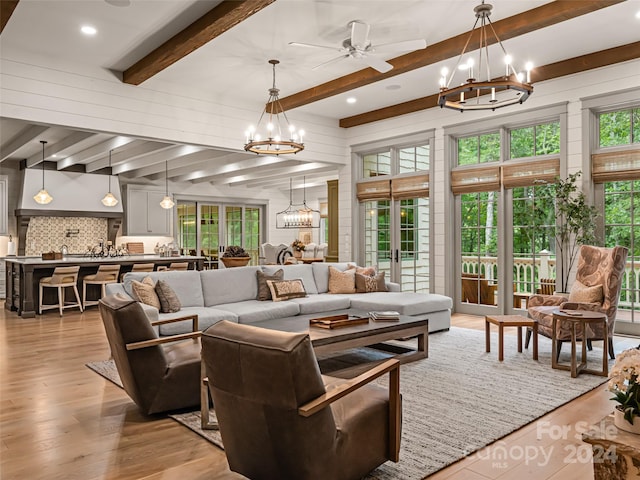 living room featuring beam ceiling, light hardwood / wood-style flooring, and ceiling fan with notable chandelier