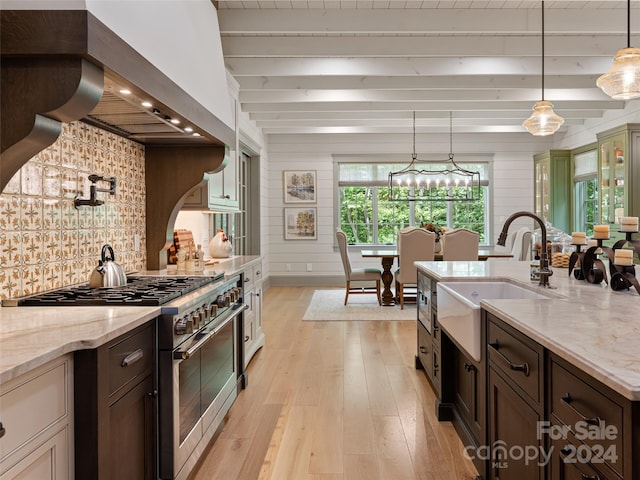 kitchen featuring light hardwood / wood-style floors, high end range, light stone counters, and beam ceiling