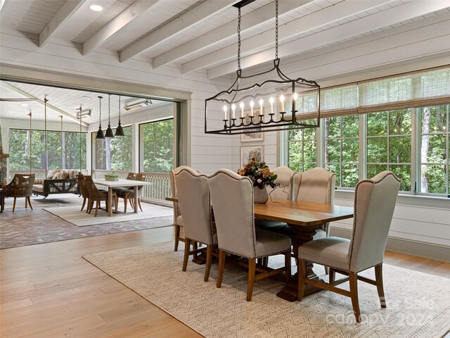 dining room with a wealth of natural light, light hardwood / wood-style floors, and an inviting chandelier