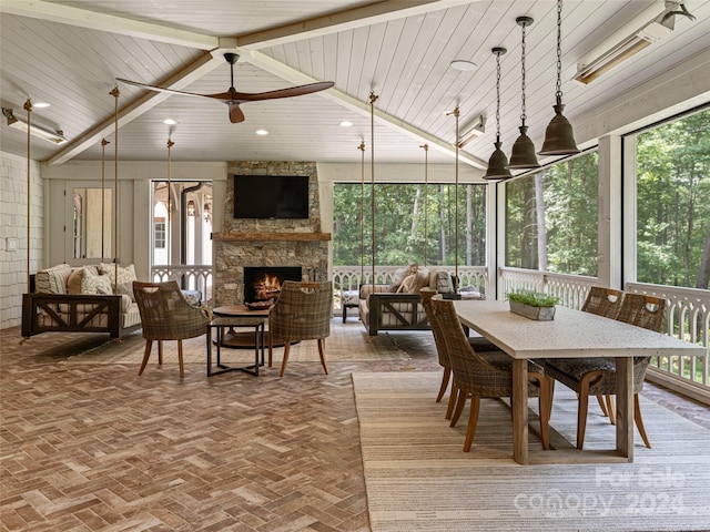 dining space featuring ceiling fan, plenty of natural light, wooden ceiling, and a fireplace