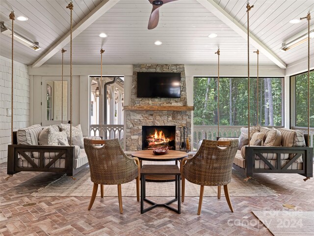 living room featuring lofted ceiling with beams, a wealth of natural light, wood ceiling, and a fireplace