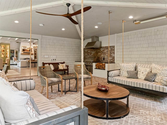 living room featuring ceiling fan with notable chandelier, lofted ceiling with beams, and brick wall