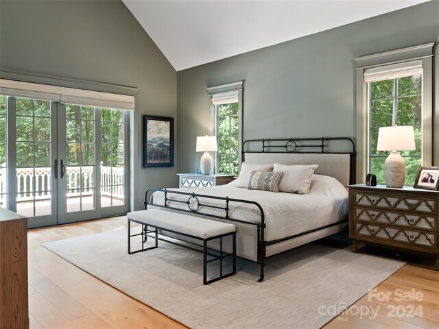 bedroom with light hardwood / wood-style floors, high vaulted ceiling, french doors, and access to exterior