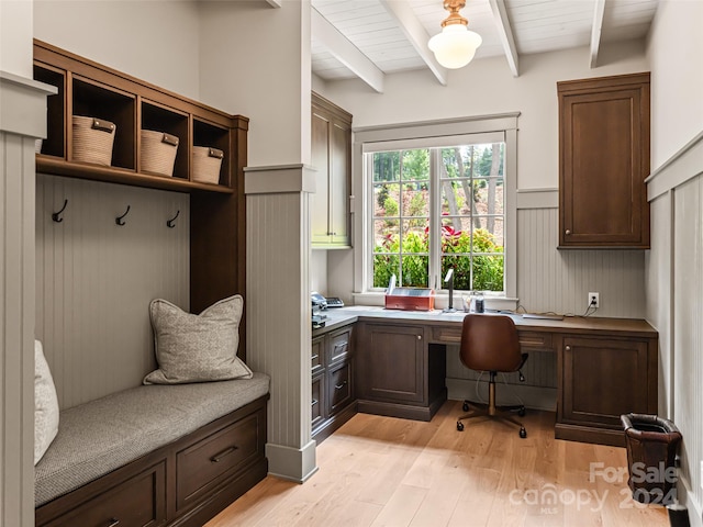 mudroom featuring built in desk, beamed ceiling, and light wood-type flooring