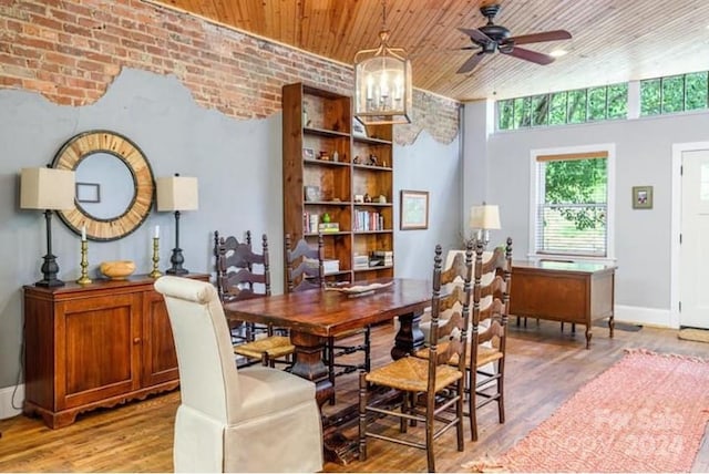 dining area featuring brick wall, hardwood / wood-style floors, ceiling fan with notable chandelier, and wooden ceiling