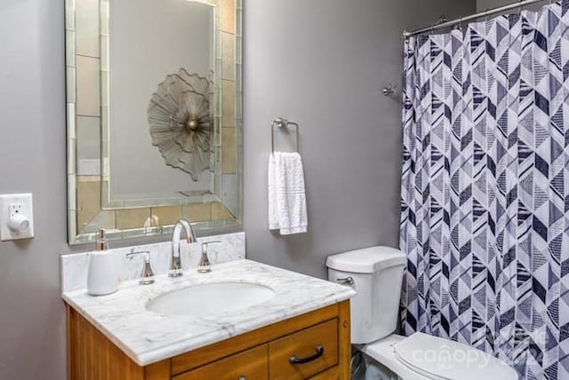 bathroom featuring vanity, a shower with shower curtain, and toilet