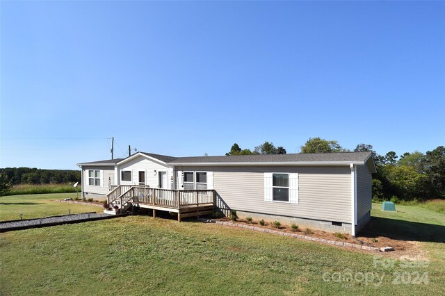 view of front facade featuring a wooden deck and a front lawn