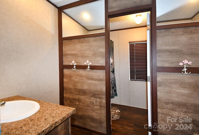 bathroom with vanity, a textured ceiling, and hardwood / wood-style flooring