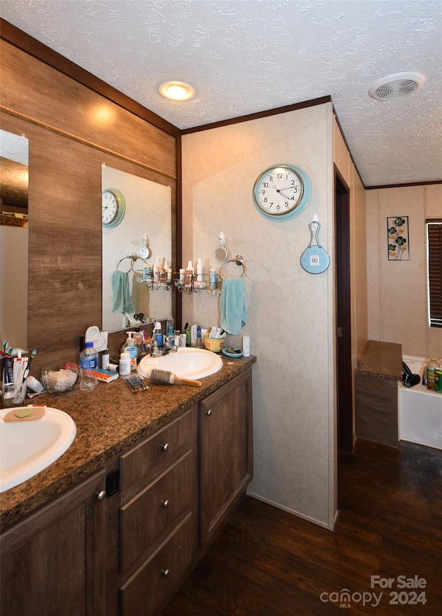 bathroom with vanity, hardwood / wood-style floors, a textured ceiling, and wood walls