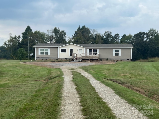 manufactured / mobile home with a front yard and a deck