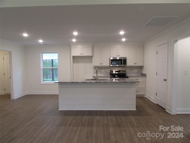 kitchen featuring white cabinets, light stone counters, stainless steel appliances, and an island with sink