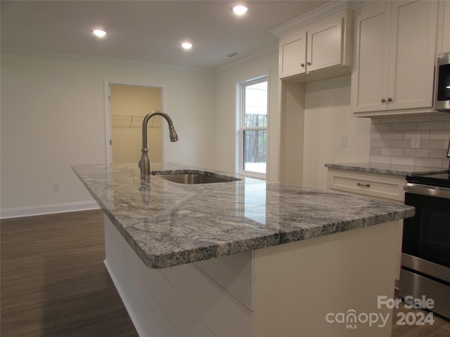 kitchen with light stone countertops, appliances with stainless steel finishes, sink, a center island with sink, and white cabinetry