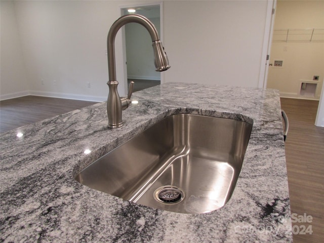 room details with dark hardwood / wood-style flooring, sink, and stone counters