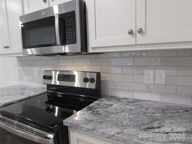 kitchen featuring tasteful backsplash, light stone counters, white cabinets, and stainless steel appliances