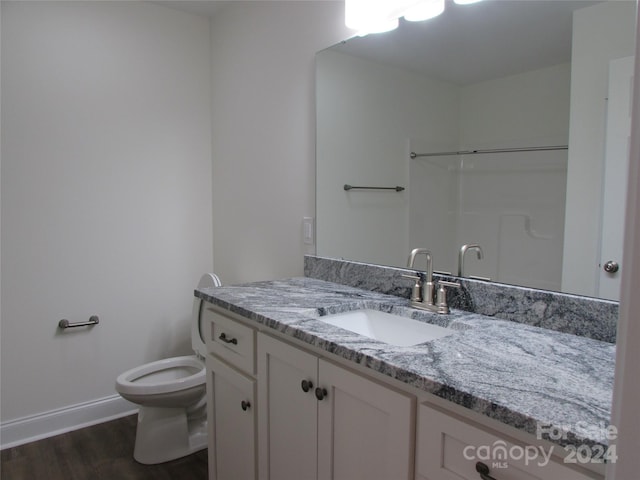 bathroom with hardwood / wood-style floors, vanity, and toilet