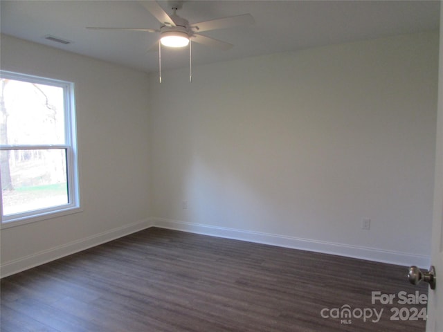 spare room featuring ceiling fan and dark wood-type flooring