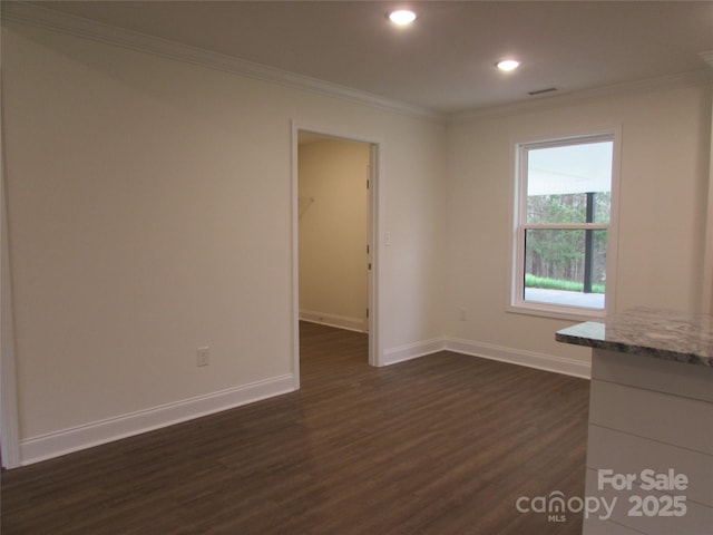 spare room with dark hardwood / wood-style flooring and crown molding