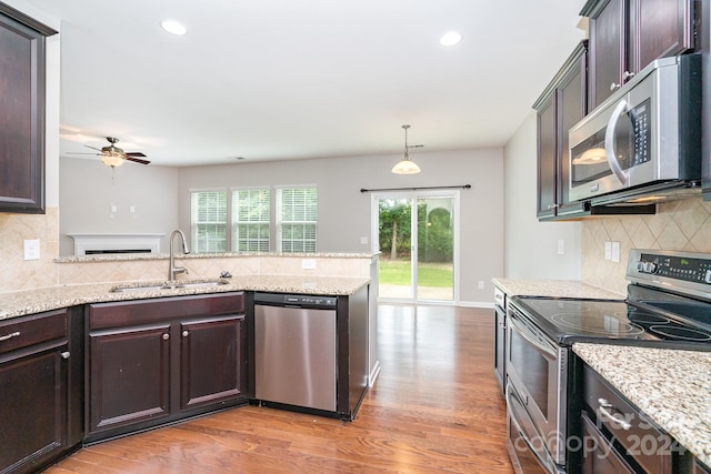 kitchen with backsplash, stainless steel appliances, light hardwood / wood-style floors, sink, and ceiling fan