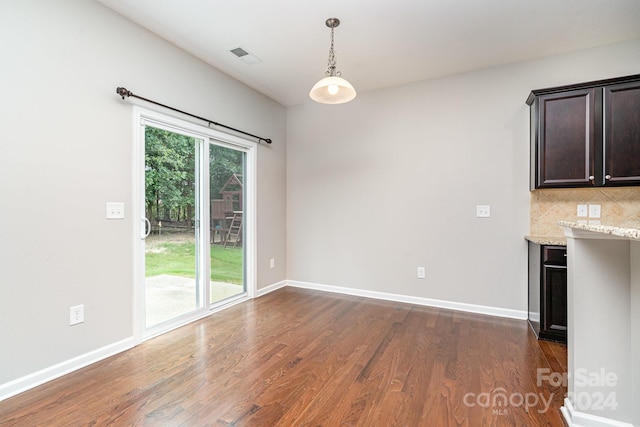 unfurnished dining area featuring dark hardwood / wood-style floors and a healthy amount of sunlight