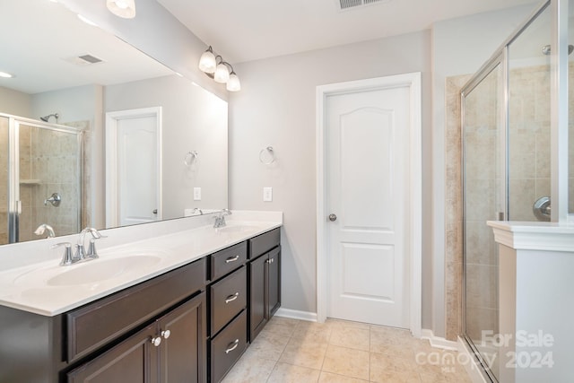 bathroom with dual vanity, tile patterned flooring, and a shower with shower door