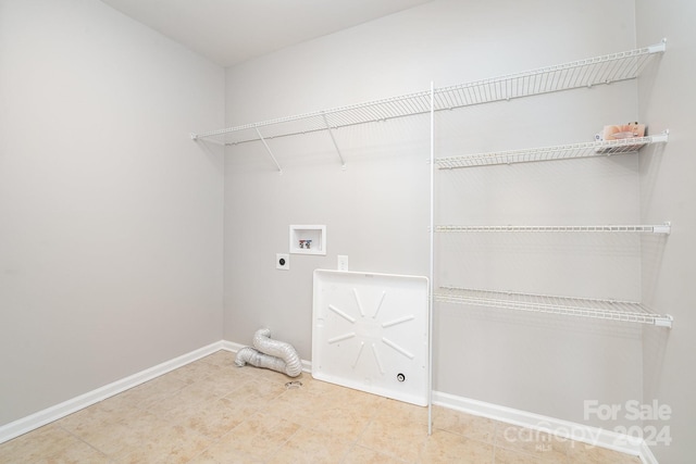 clothes washing area featuring hookup for an electric dryer, tile patterned flooring, and washer hookup