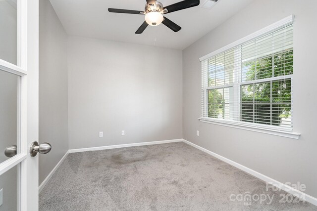 unfurnished room with ceiling fan and carpet