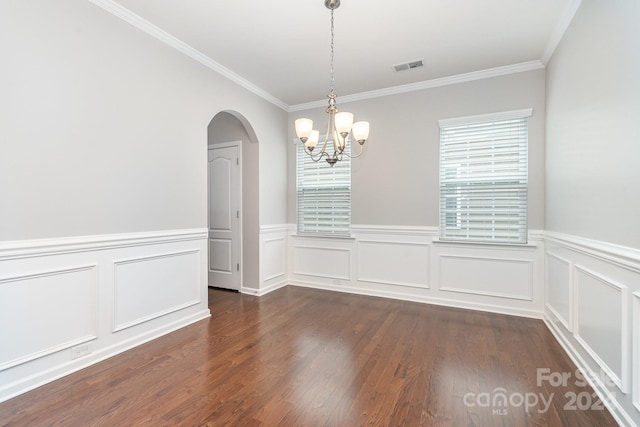 unfurnished dining area featuring crown molding, dark hardwood / wood-style flooring, and a chandelier