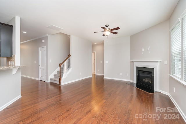 unfurnished living room with hardwood / wood-style floors, plenty of natural light, ceiling fan, and ornamental molding