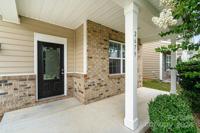 view of exterior entry featuring covered porch