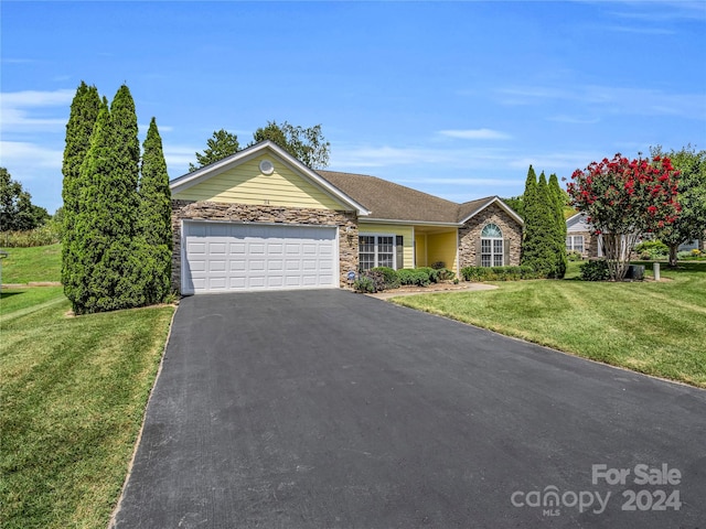 ranch-style home featuring a garage and a front lawn