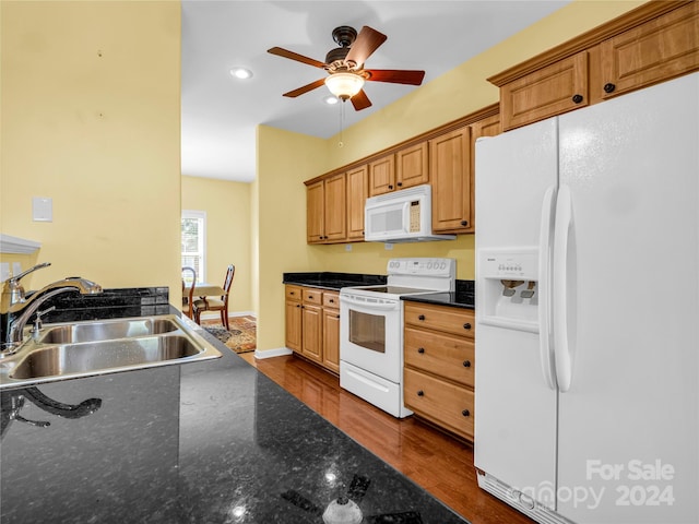 kitchen with dark hardwood / wood-style floors, sink, dark stone counters, white appliances, and ceiling fan