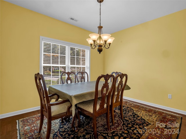 dining space with visible vents, baseboards, dark wood-type flooring, and a notable chandelier