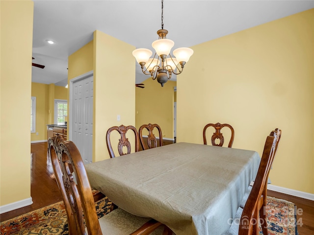 dining space featuring ceiling fan with notable chandelier and hardwood / wood-style flooring