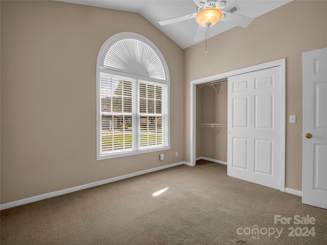 unfurnished bedroom featuring ceiling fan, a closet, vaulted ceiling, and carpet floors