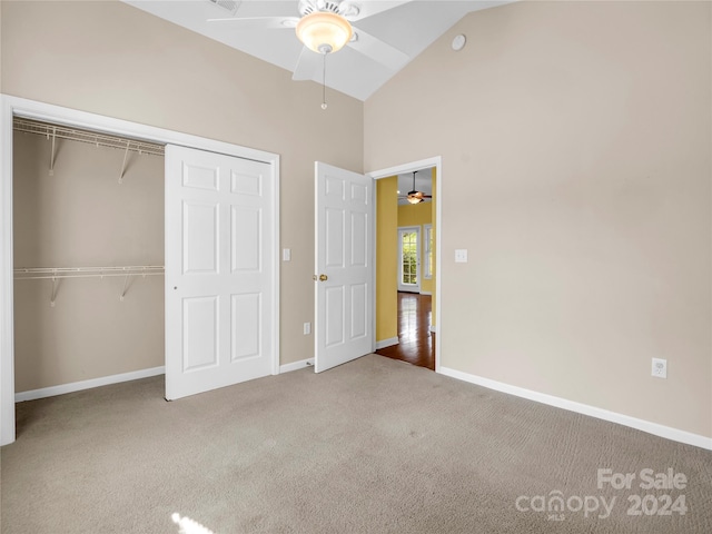 unfurnished bedroom featuring ceiling fan, a closet, high vaulted ceiling, and hardwood / wood-style floors