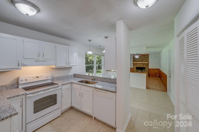 kitchen with white appliances, white cabinets, a sink, and under cabinet range hood