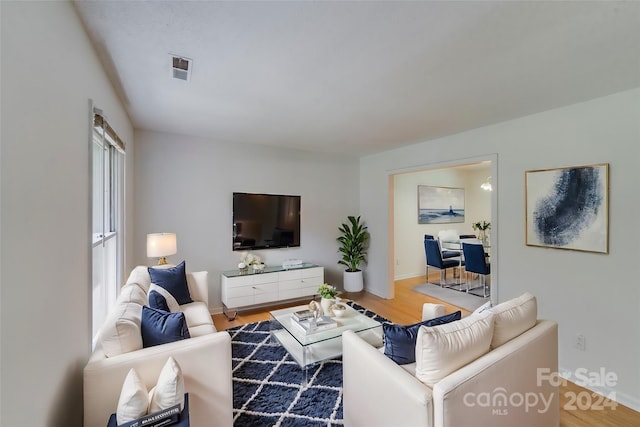 living area with wood finished floors and visible vents