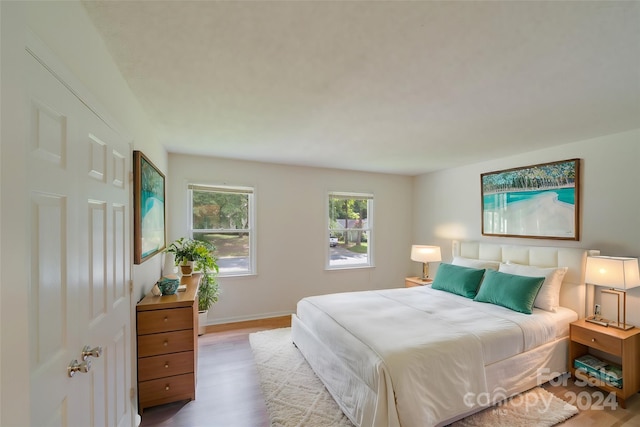 bedroom featuring light wood-style floors and baseboards