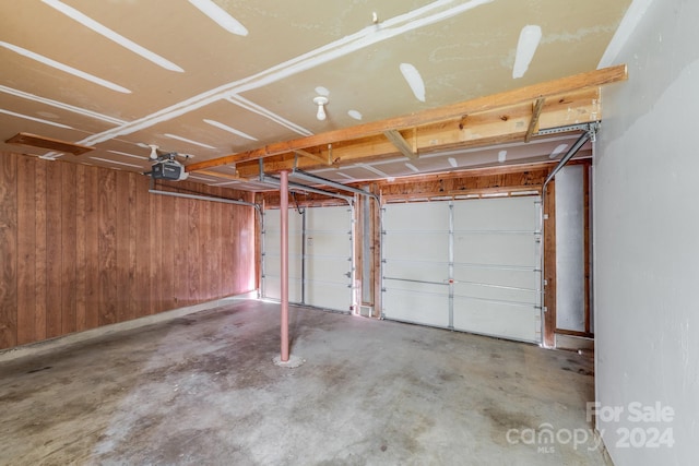 garage with wood walls and a garage door opener